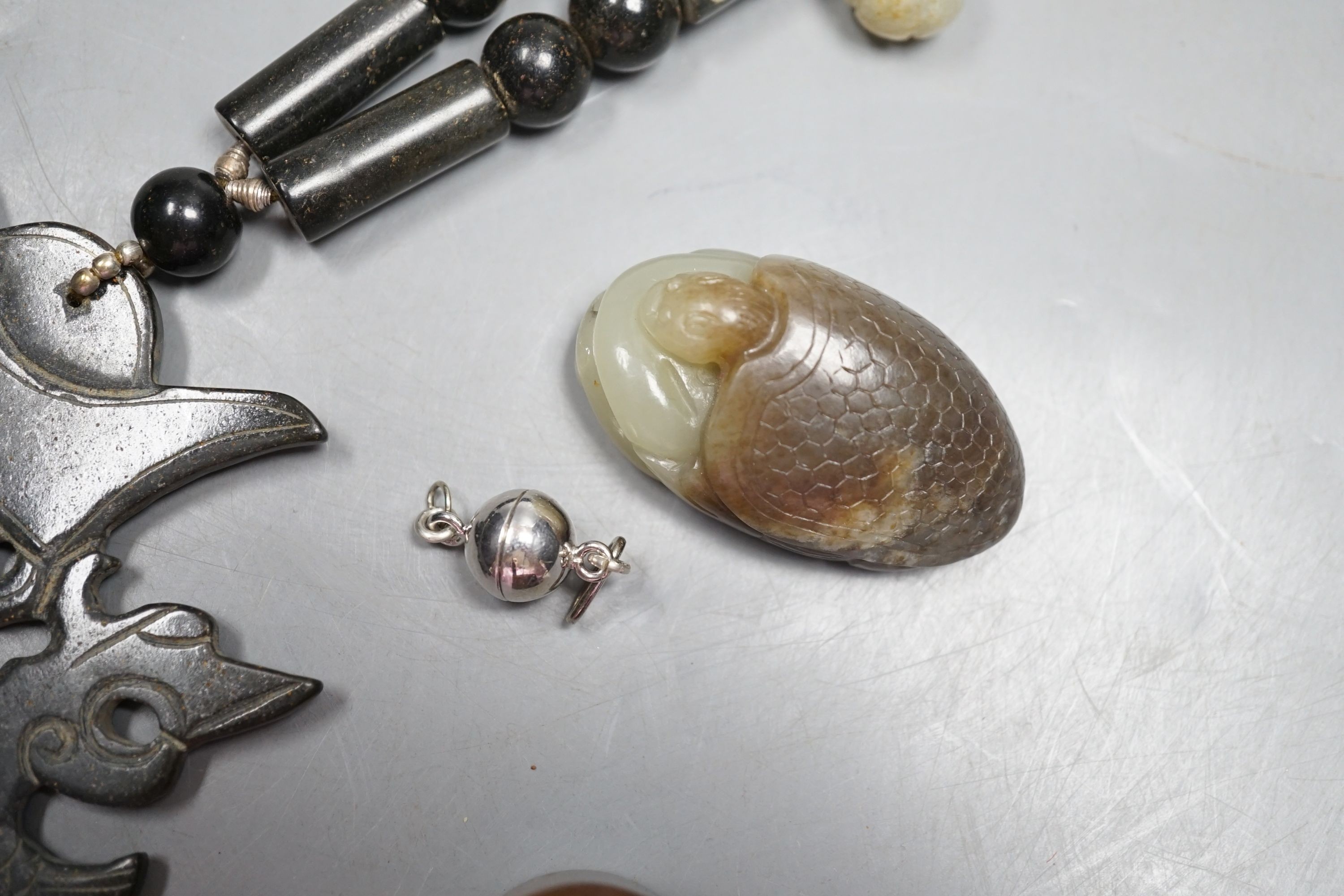 Kai Yin Lo of Hong Kong, a jade turtle and snake pendant, jade archer’s ring and two beads, formerly strung on a necklace together with a hardstone necklace